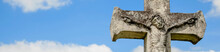 Beautiful Very Old And Ancient Statue Of The Crucifixion Of Jesus Christ Against Blue Sky With Clouds. Horizontal Image.