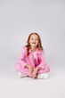 © Julie Boro - cute girl in a pink tracksuit sits on the floor