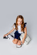 © Julie Boro - cute girl in school uniform is sitting next to a school backpack
