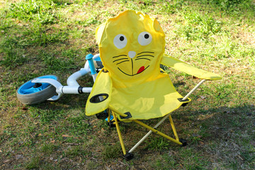 Children's folding tourist chair. Standing in a clearing in a campsite