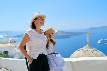 Mother and daughter child walking together on famous tourist island of Santorini