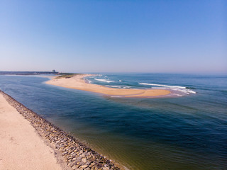 The two sides of Restinga de Ofir. One facing the ocean, the other the estuary of Cávado River. The jetty structure that protects the coastline from the currents and tides in Esposende, Portugal.