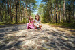 two beautiful little girls on the road in a pine forest