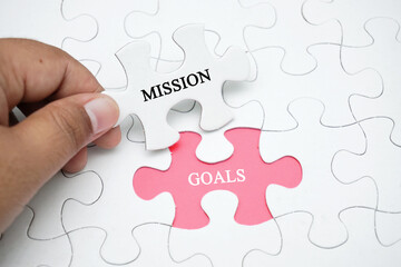 Missing puzzle with a word MISSION GOALS. Business concept puzzle piece. Business and finance concept.