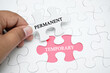 © dzakymurad - Missing puzzle with a word PERMANENT TEMPORARY. Business concept puzzle piece. Business and finance concept.