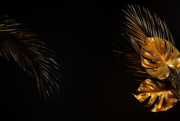 Gold leaf isolated on a black background  top view. Gold palm, monstera leaves , plant frame with copy space. abstract poster.