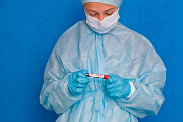 Blood test. A young medical worker holds a blood tube with the inscription covid-19