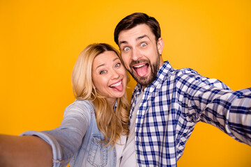 Sticker - Closeup photo of blond lady handsome guy funky couple spend quarantine together making selfies fooling around stick tongue out mouth wear casual shirts isolated yellow color background