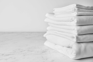 Stack of clean bed sheets on table