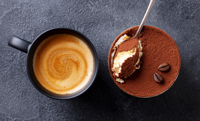 Canvas Print - Tiramisu dessert with cup of coffee. Dark background. Close up. Top view.