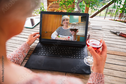 Fotografía Friends talking in video call with device at distance in lockdown and quarantine