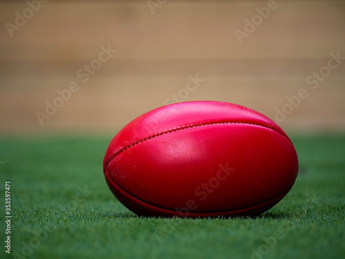 Red Australian Rules Football on Grass in a backyard