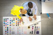 © FILEOPEN CREATION - Top view, Senior female designer is talking to a male designer in a tailor shop. Concept. Retired designers working at home, creating income for the elderly