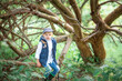© Ирина Трухина - 5 year old blond boy in a cap sitting on a branching tree