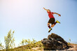 © Med Photo Studio - Young sportsman football player is jumping from the rock mountain
