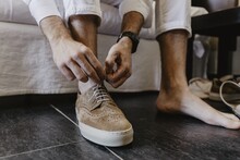 Horizontal Shot Of A Man Tying Shoelaces Of Brown Shoes
