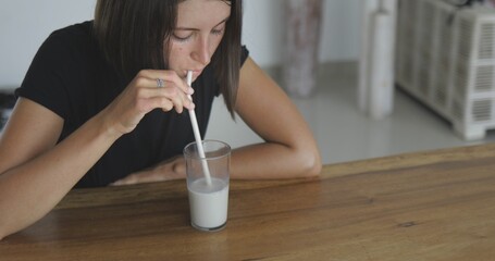 Wall Mural - Pretty girl drinks oat multy grain milk from glass straw