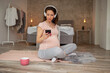 © Impact Photography - Pregnant woman choosing a song from a smart phone playlist