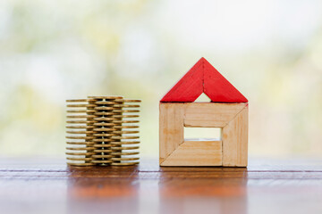 Wall Mural - Coins stack with house model on wooden table, Estate service concept,Saving money for real estate with buying a new home and loan for prepare in the future concept.