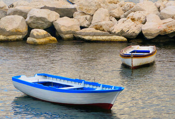 Wall Mural - Sea port of city of Naples with small fishing boats on water with colorful sun reflections, Napoli Italy       