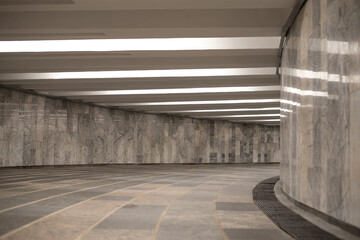  illuminated by white artificial light empty pedestrian tunnel lined with marble tiles goes to the right