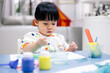 Asian toddler girl is painting water color. toddler activity at home.