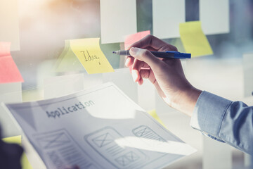 Designer men pointing stick note planning develop application develop for mobile phone.