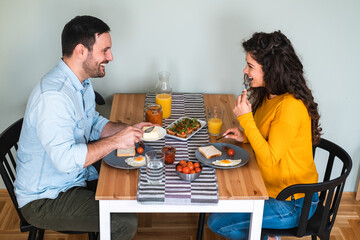 Wall Mural - Happy couple having breakfast together in kitchen stock photo