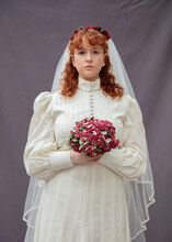 Young Woman With Curly Red Hair Wearing A Vintage Style Wedding Dress.
