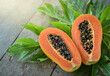Half cut papaya placed on a wooden background.Papaya fruit on wooden background.close up papaya image. 