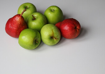 red pears and juicy green apples on a white background