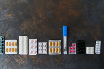 Wall Mural - Pills capsules medicine health on dark background top view, medical pharmacy concept. Different pills on dark background with copy space.