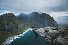 Man Hanging Off Cliff At Ryten Mountain In Lofoten Islands