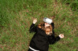 © Maxim - girl with virtual reality glasses lies on the grass with a surprised face