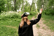 © Maxim - girl stands in the middle of the forest in virtual glasses is surprised stretches her hand to the top