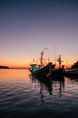 Wall Mural - Traditional thai fisghing boats in the sea at twilight in Thailand