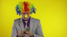 Clown Businessman Entrepreneur Counts Money Income. Hand Steals Cash From Man