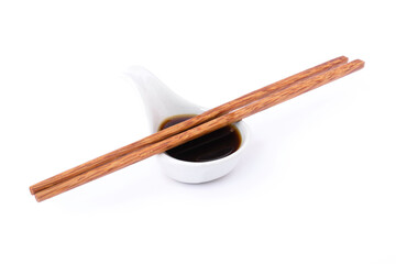 Wall Mural - Tasty soy sauce in small ceramic bowl and wooden chopsticks isolated on white background. 