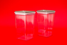 Transparent Plastic Containers For Storing Bulk Products, Cereals And Pasta, Photographed Large On A Red Background.