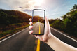 © ATKWORK888 - Open asphalt road through mobile phone at golden sunset and beautiful blue sky.