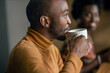© JonoErasmus - Smiling African businessman drinking coffee in an office