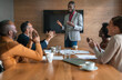 © JonoErasmus - Diverse businesspeople clapping after a presentation in an office