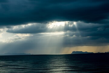 Rays of light breaking thru rain storm clouds in Asia