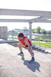 © miguel - Joven runner haciendo estiramientos en el parque después de practicar ejercicio físico