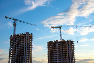 Wall Mural - Preparing to pour a bucket of concrete into formwork.Tower crane lifting cement bucket during construction a multi-storey residential building. Construction cranes and builders in action