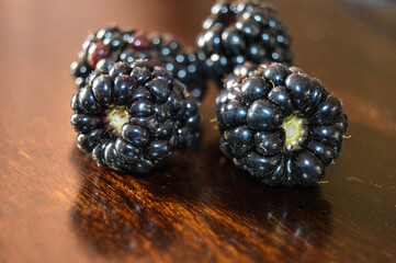 Macro shot of organic , fresh and healthy blackberry , blackberries on a wooden brown background