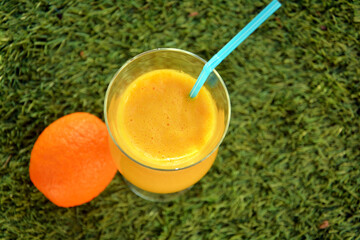 Glass of  fressh orange juice on the grass 