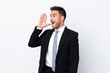 © luismolinero - Young business man over isolated background shouting with mouth wide open