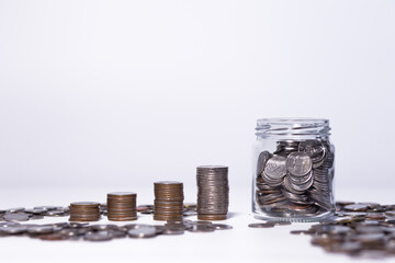 Saving money by hand puting coins in jug glass on white background