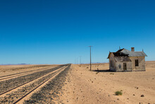 Railway Track In Desert With Old Train Station